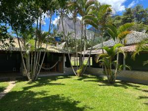 a house with palm trees and a mountain in the background at Casa Vista Pedra Azul in Domingos Martins
