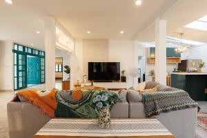 a living room with a couch and a tv at Summer Eternal Pool Villa Nimman in Chiang Mai