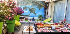 a table with food on a balcony with a view of the ocean at Chambres d'hôtes Chez Pat et Nanou in Six-Fours-les-Plages