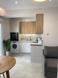 a kitchen with white appliances and a table in a room at Modern Athens Apartment with Large Private Balcony in Athens