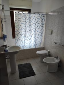 a bathroom with a sink and a toilet and a shower at Casa Marina in Sestu
