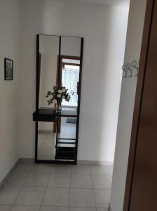a mirror in a room with a vase of flowers at Casa Marina in Sestu +3 photos