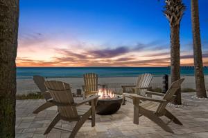 three chairs and a fire pit on the beach at Calypso Beach Resort Towers in Panama City Beach +5 photos