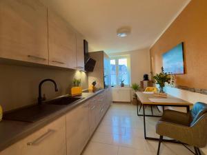 a kitchen with a sink and a table at Ferienwohnung 1 im Beachhouse am Goitzschesee - strandnah, familienfreundlich & komfortabel in Bitterfeld
