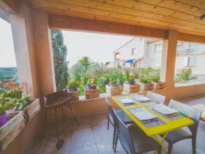 a yellow table and chairs on a balcony with potted plants at Casa Ghjuvanna in Propriano +5 photos