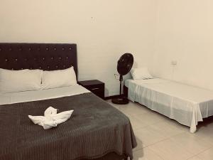 a hotel room with two beds with white sheets at Hotel Casa Corleone in Garzón