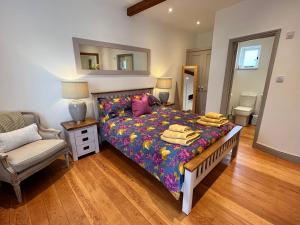 Un dormitorio con una cama, una silla y un espejo. en The Manor Coach House, en Canterbury