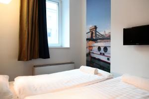 a bedroom with two beds and a window at Maverick Budapest Soho in Budapest
