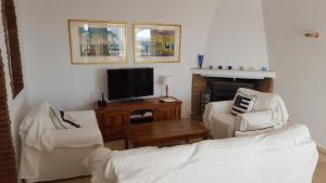 a living room with two chairs and a television at El Capistrano Sur in Nerja