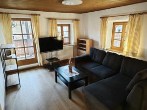 a living room with a couch and a flat screen tv at Gasthaus Staufenbrücke in Bad Reichenhall