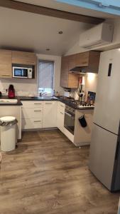 a kitchen with white appliances and wooden floors at MOBILHOME Soulac in Soulac-sur-Mer +7 photos