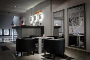 ドンブロヴァ・グルニチャにあるZajazd Kwadratの黒い椅子とテーブルと鏡のあるレストラン