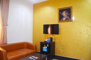 a hotel room with a couch and a painting on the wall at Residency Apartment and Hotel Guzape Hills Abuja in Abuja