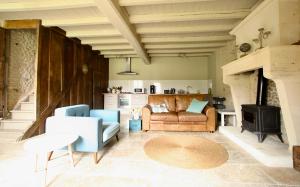 Una sala de estar con un sofá y una chimenea. en La Cannonerie, en Réaux