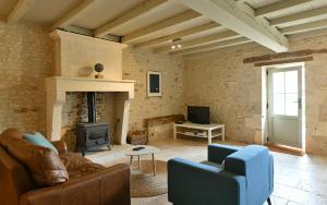 Una sala de estar con un sofá y una chimenea. en La Cannonerie, en Réaux