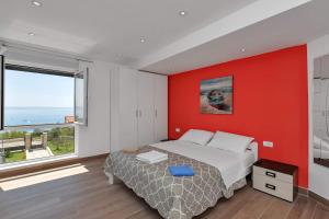 a bedroom with a bed and a red wall at Villa Infinite Joy in Makarska