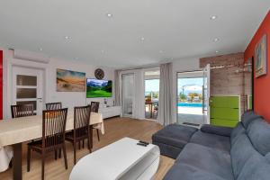 a living room with a blue couch and a table at Villa Infinite Joy in Makarska