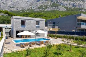 a house with a swimming pool next to a building at Villa Infinite Joy in Makarska