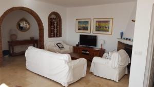 a living room with two white couches and a tv at El Capistrano Sur in Nerja
