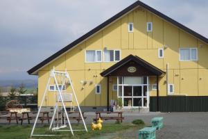 a yellow building with a fire hydrant in front of it at B&B Ken&Mary in Biei