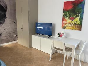 a dining room with a white table and a tv at Panoramic Condo in Tirana! in Tirana