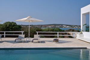 een zwembad met twee stoelen en een parasol bij Empire Luxury Villas in Santa Maria