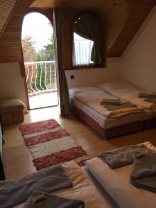 a bedroom with two beds and a large window at Káptalan vendégház in Balatonalmádi +38 photos