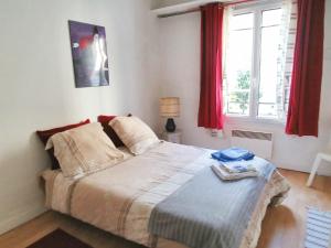 a bedroom with a large bed with red curtains at Maison confortable à Montreuil avec jardin clôturé in Montreuil