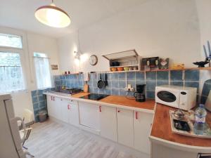a kitchen with a sink and a microwave on a counter at Maison confortable à Montreuil avec jardin clôturé in Montreuil