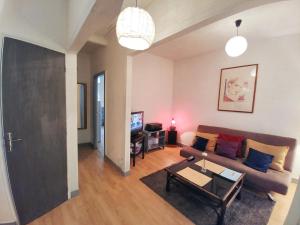 a living room with a couch and a table at Maison confortable à Montreuil avec jardin clôturé in Montreuil