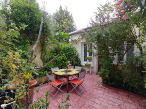 a patio with a table and chairs in a garden at Maison confortable à Montreuil avec jardin clôturé in Montreuil