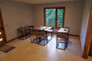 a room with four tables and chairs and a window at Lodge Agua de la Piedra in Valdivia