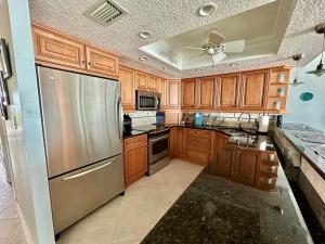 a kitchen with wooden cabinets and a stainless steel refrigerator at Sand Dollar 3-304 in Saint Augustine