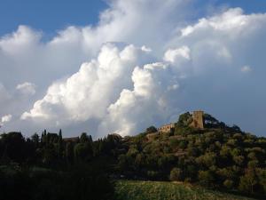 budynek na szczycie wzgórza z chmurami w obiekcie Appartamento con vista panoramica w mieście Pienza +5 zdjęć