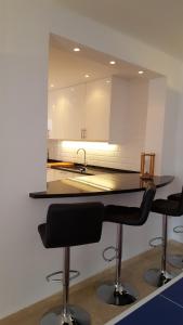 a kitchen with two bar stools and a mirror at El Capistrano Sur in Nerja