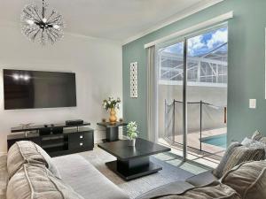 ein Wohnzimmer mit Couch und Flachbildfernseher in der Unterkunft Luxury 4 Bedroom 3 bathroom pool Home 258 in Davenport