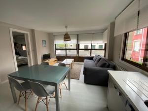a living room with a table and a couch at Housingcoruña Apartamento Playa Miño 04 in Miño