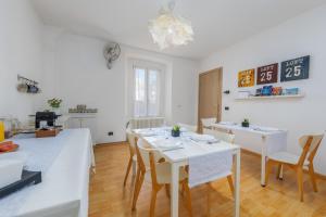 una sala da pranzo con tavolo e sedie bianchi di TiglioExperienceComo a Como