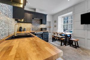 a kitchen with black cabinets and a wooden counter top at Warden's Close Apartments in Edinburgh