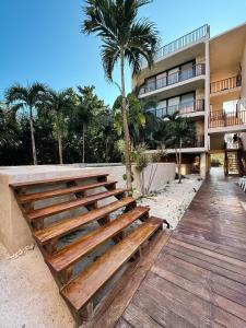 a wooden bench in front of a building at BOHO Loft Steps from the Beach in Holbox Island
