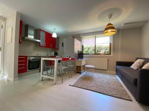 a kitchen and living room with a couch and a table at Housingcoruña Apartamento Playa Miño 02 in Miño