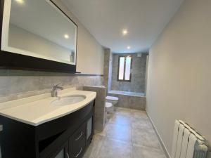 a bathroom with a sink and a toilet and a mirror at Housingcoruña Apartamento Playa Miño 02 in Miño +5 photos