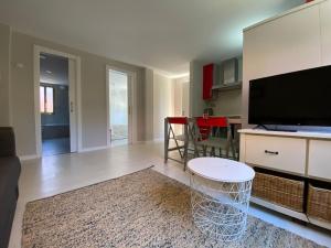 a living room with a flat screen tv and a table at Housingcoruña Apartamento Playa Miño 02 in Miño