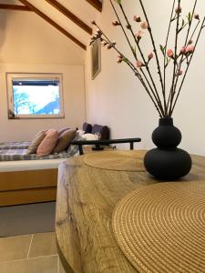 a room with a table with a vase with flowers at Altiora in Subotica