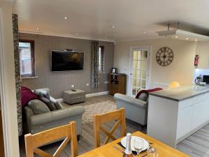 a kitchen and living room with a couch and a table at Nelly's Nest in Bridlington