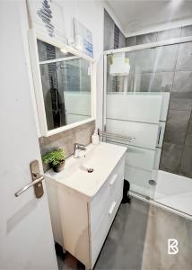 a white bathroom with a sink and a shower at Comfortable house 20 minutes from Paris by RER in Brétigny-sur-Orge +4 photos