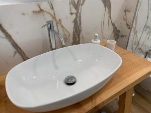 a white sink on a wooden table in a bathroom at IL COMO' DELLA CIVETTA - Nido della Civetta in Villa di Tirano +11 photos
