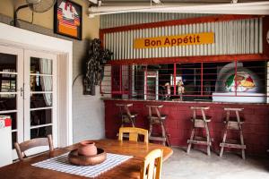 a restaurant with a wooden table and chairs and a bar at Colenso Lodge B&B in Colenso