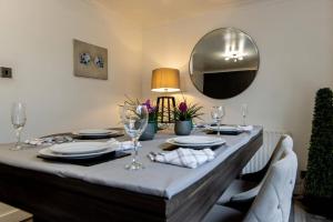a dining room table with a grey table cloth and a mirror at HouseSleep14-FreeP-Garden-Bbq-Patio-PoolTable in London