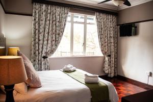 a bedroom with a large bed with a window at Colenso Lodge B&B in Colenso